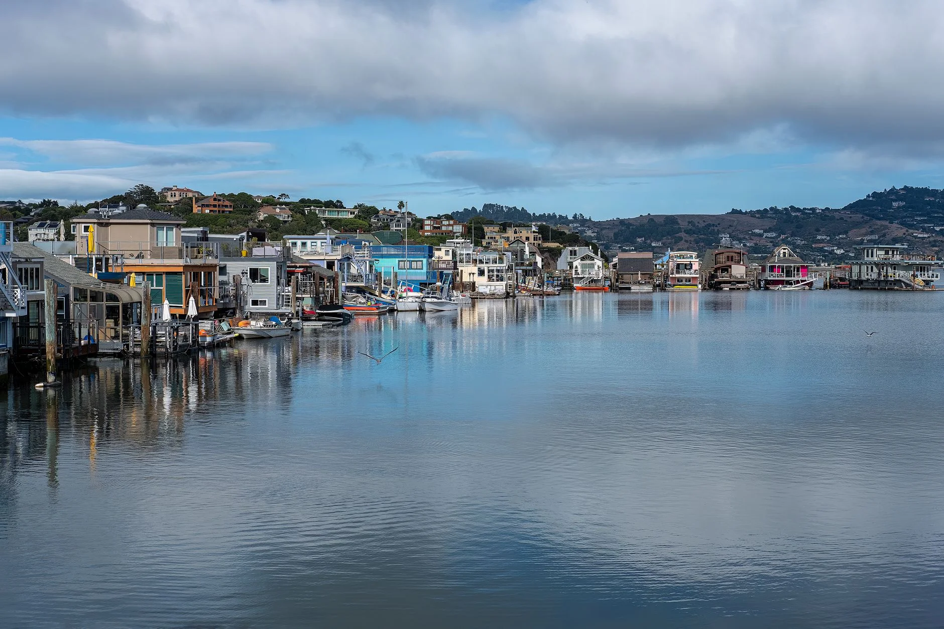 A scenic view of a houseboat anchored at a tranquil marina